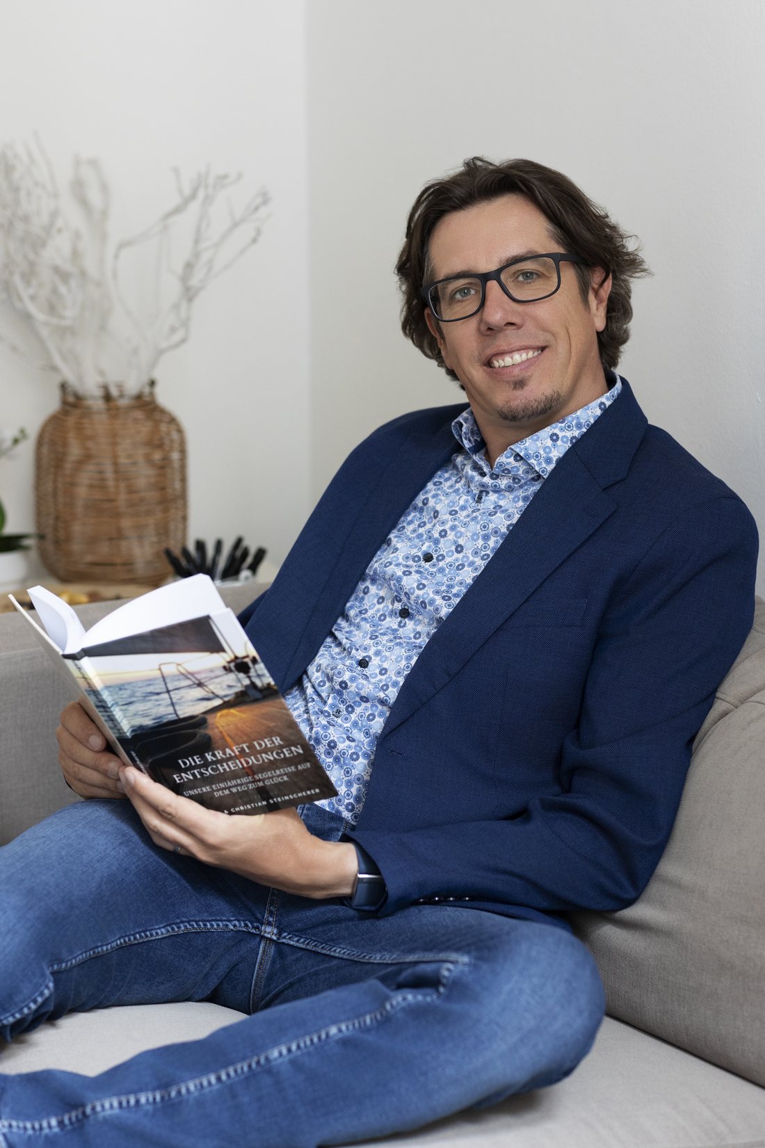 Christian Steinscherer auf dem Sofa, ein Magazin in der Hand